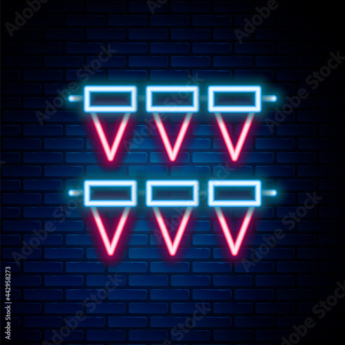 Glowing neon line Carnival garland with flags icon isolated on brick wall background. Party pennants for birthday celebration, festival decoration. Colorful outline concept. Vector