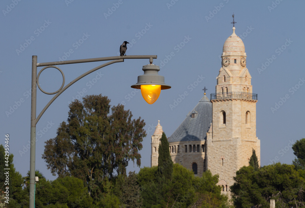 Jerusalem: Abbey of the dormition and street lamp in the Park. The Raven sits on the lamp