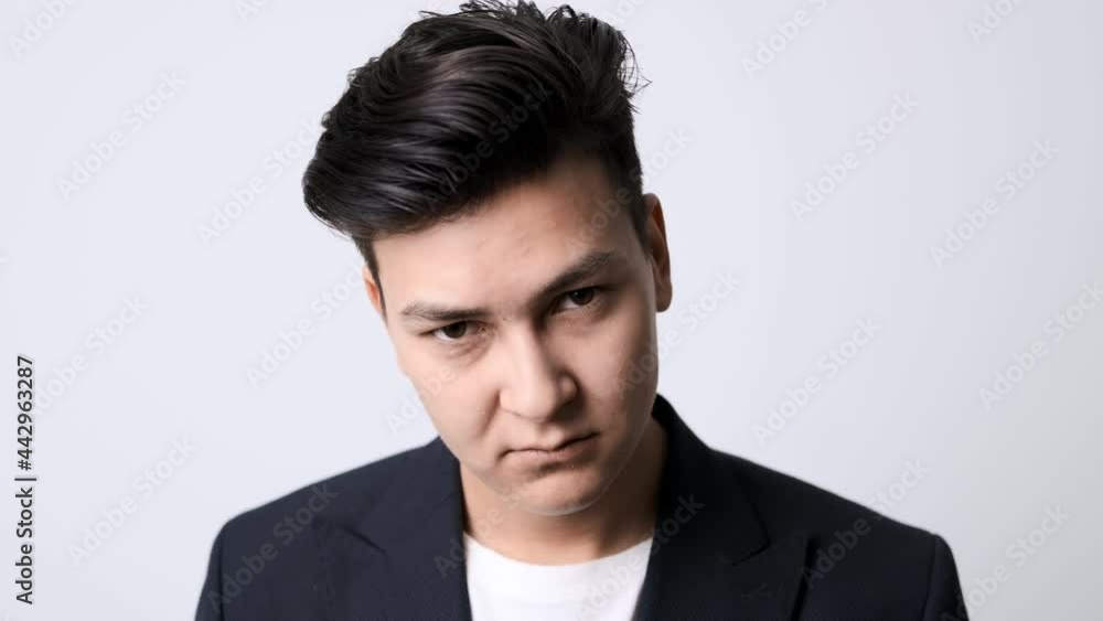 A young attractive guy with a serious look looks at the camera. On white A young attractive guy with a serious look looks at the camera. On white
