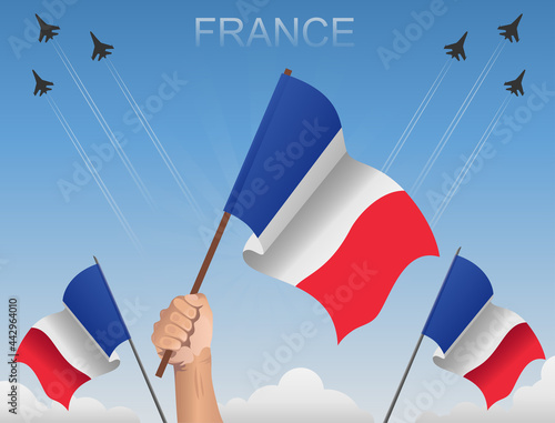 The flags of France flutter under the blue sky