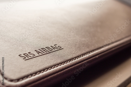 airbag safety sign on brown leather texture in modern car