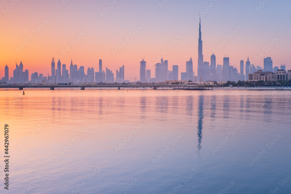 sea bay with reflections of skyscrapers in water in Dubai in the morning with copy space