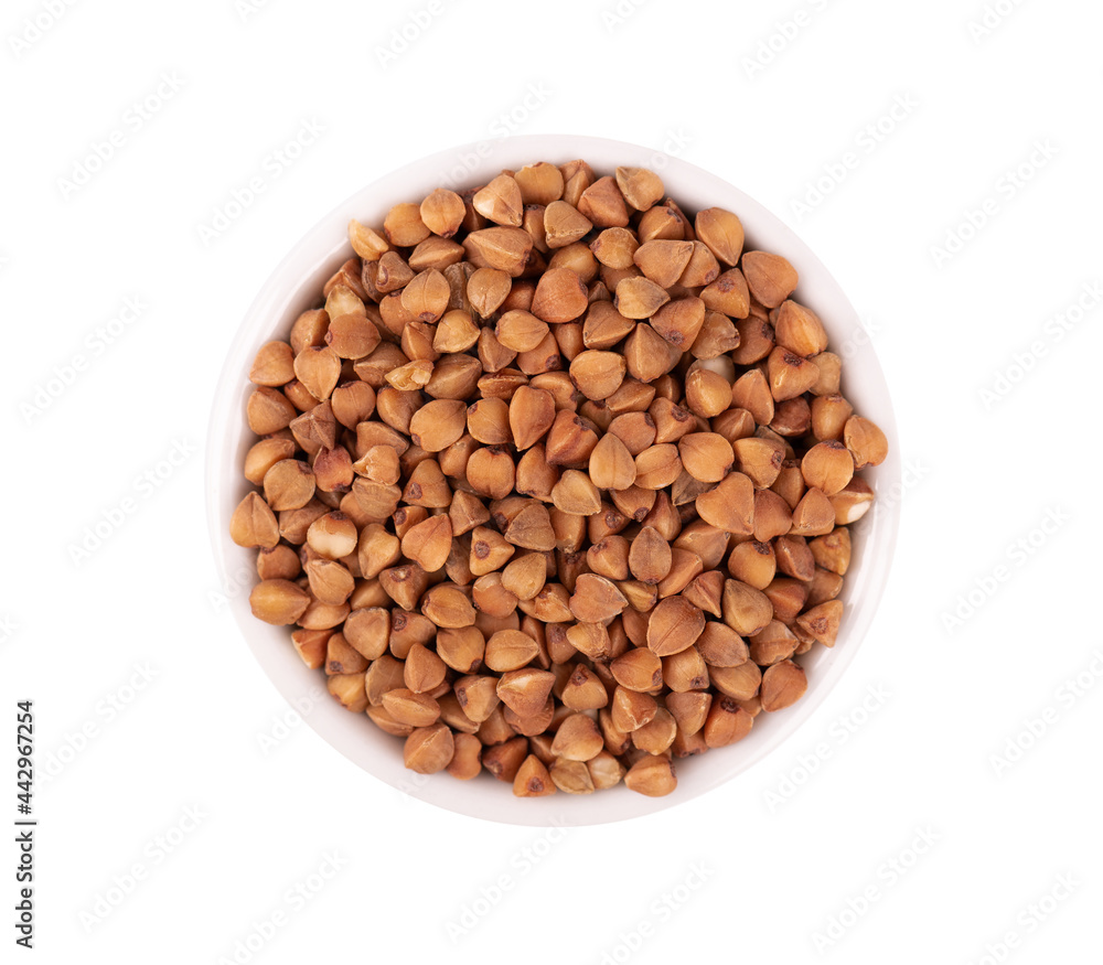 Roasted buckwheat grains in bowl, isolated on white background. Dry brown buckwheat groats. Top view.
