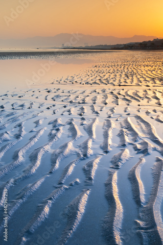 sea coast line in sunrise with lines on the beach