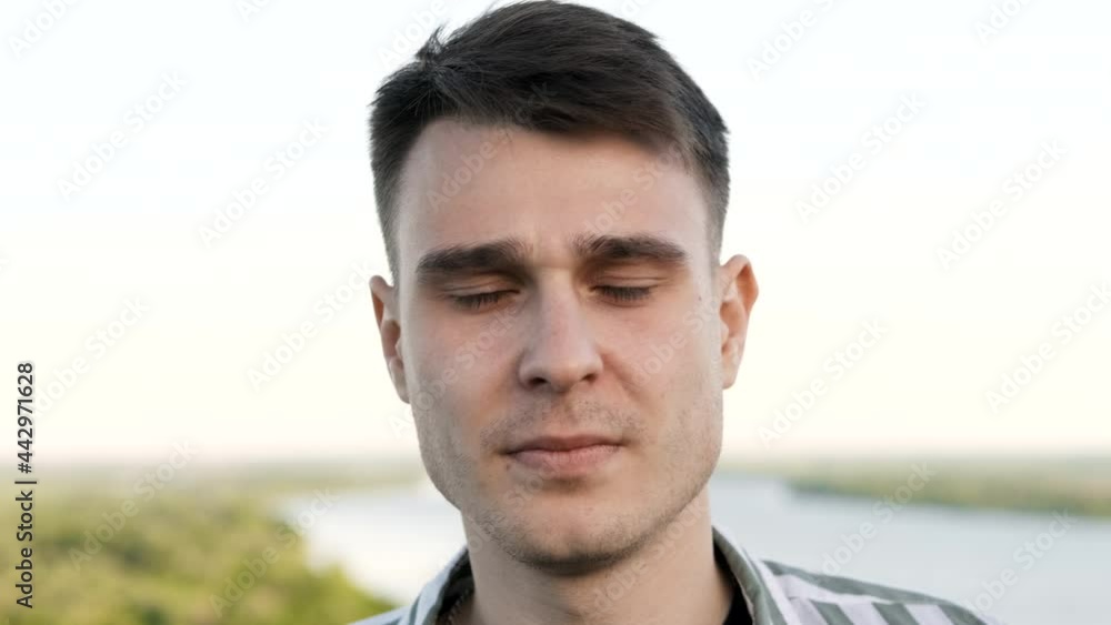 Close-up face of a young attractive caucasian guy looking with a serious look Close-up face of a young attractive caucasian guy looking with a serious look