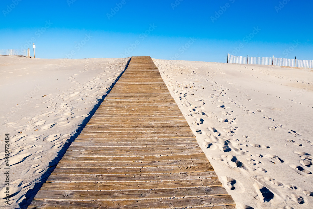 A wooden boardwalk leading to the beach over a sand dune at Assateague Island, Maryland