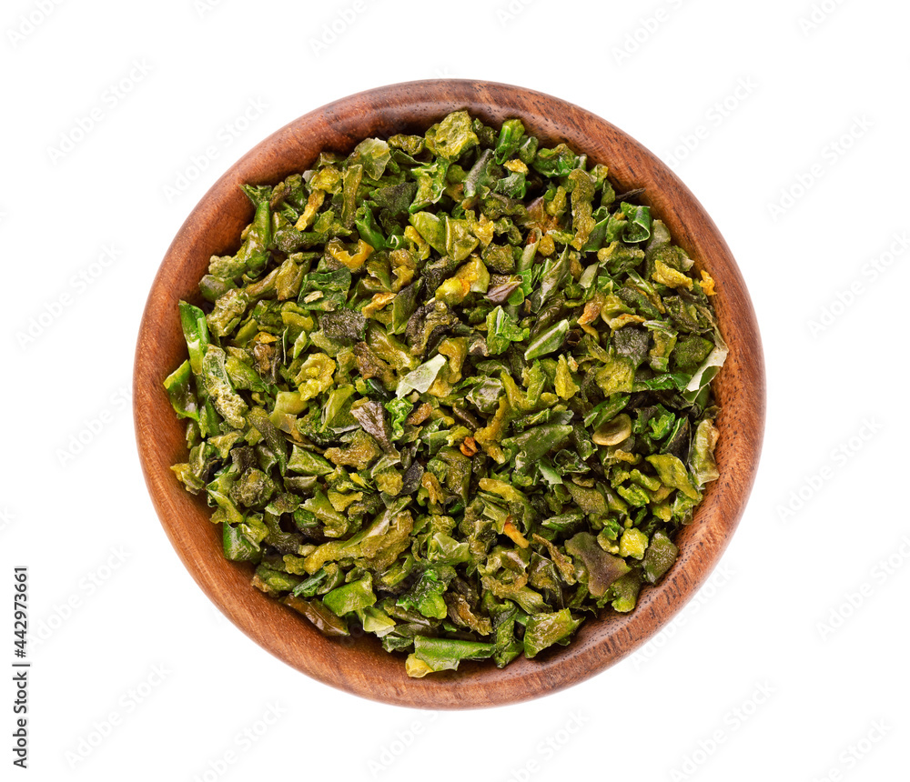 Dried green paprika flakes with seeds in wooden bowl, isolated on white background. Chopped jalapeno, habanero or chilli pepper. Spices and herbs. Top view. Dried green paprika flakes with seeds in wooden bowl, isolated on white background. Chopped jalapeno, habanero or chilli pepper. Spices and herbs. Top view.