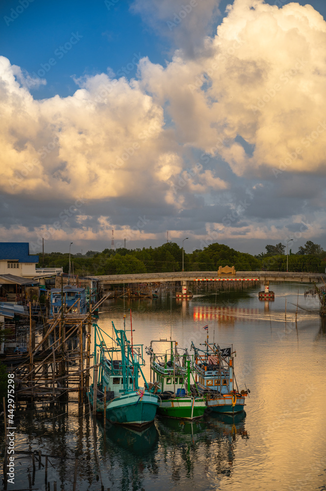 Fototapeta premium Thai fishing boats moored at the pier in the evening at sunset in fishing village, Ban Pak Nam Khaem Nu, Chanthaburi, Thailand.