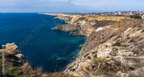 View of the Black Sea and the city of Sevastopol from Cape Fiolent. Brown cliffs with sunburned grass contrast with the blue of the sea
