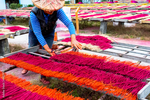 China Fujian Province Dapu Yongchun. A worker skillfully spreads the incense sticks across the drying racks. photo