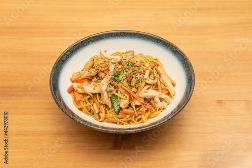 Yakisoba noodles sauteed with carrots, zucchini and chicken strips with poppy seeds and sesame with chives