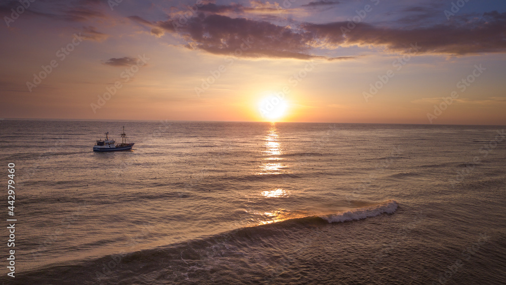 Aerial view on beach at sunset with fishing boat Aerial view on beach at sunset with fishing boat