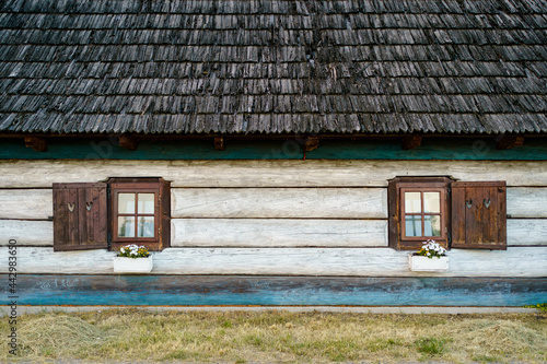 Traditional wooden white and blue vintage house with a wooden roof. Polish village.
