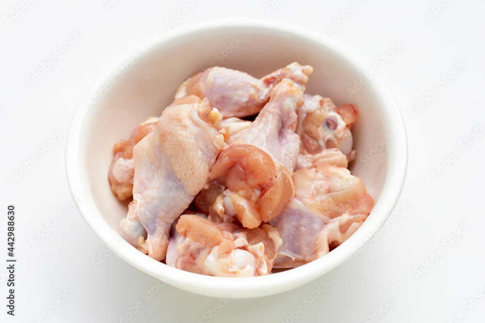 Fresh raw chicken wings (wingstick) in white plate on yellow background. Fresh raw chicken wings (wingstick) in white plate on yellow background.