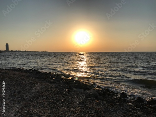 sunset and the boat sailing alone in the sea