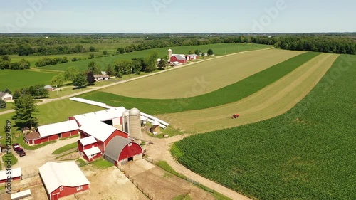 Countryside summer landscape. Farms, agricultural fields, tractor working in field. Birds eye view of Midwest USA. Daytime, sunny