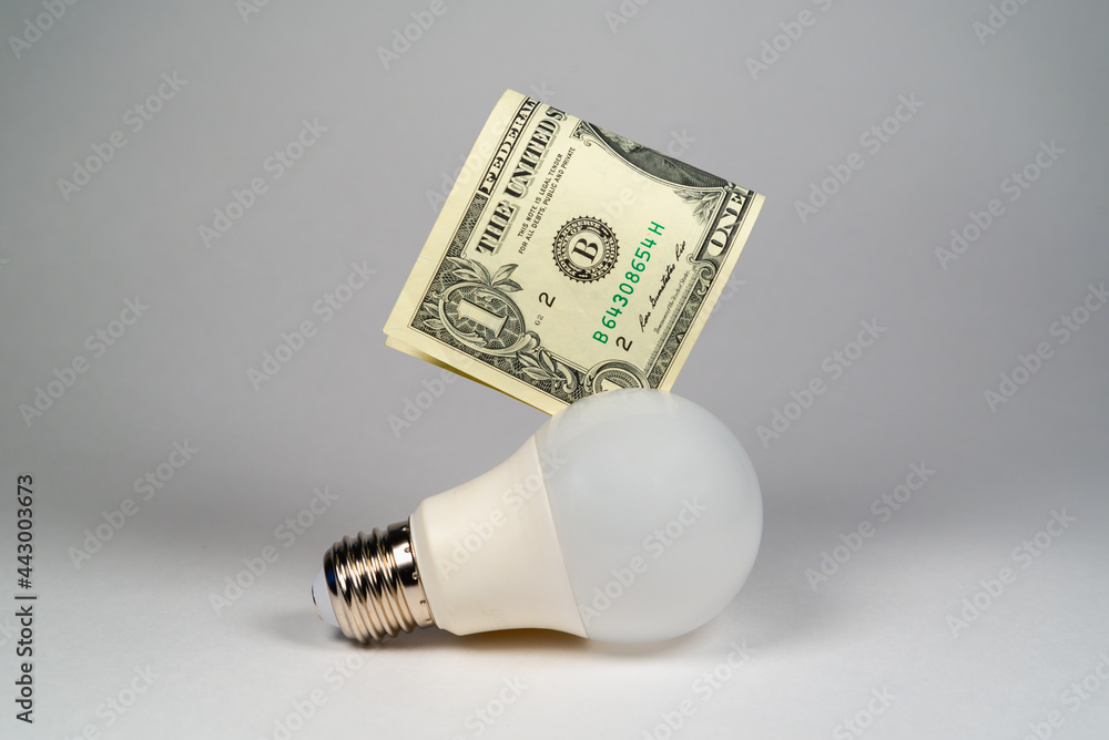 Energy saving light bulb and money (US dollar), money economy concept. Energy saving light bulb and money (US dollar), money economy concept.