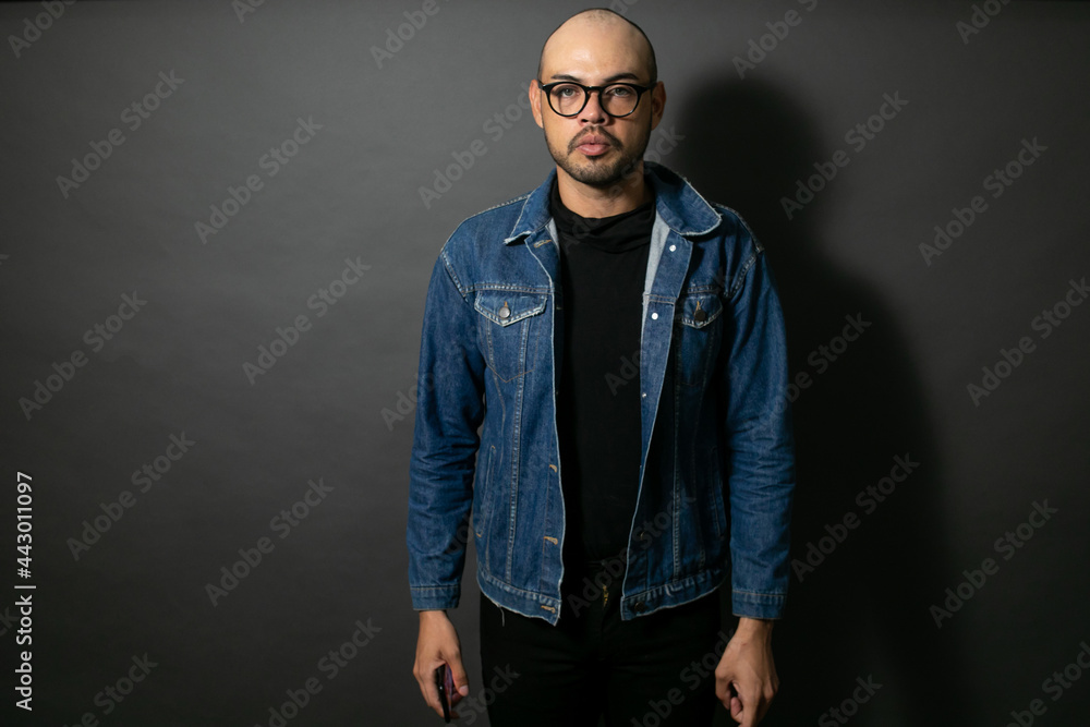 Hombre calvo guapo con camisa negra y chamarra de mezclilla