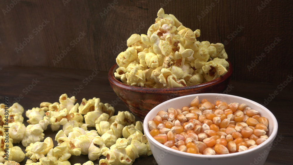 Heap of delicious popcorn. Scattered popcorn texture background. Selective focus. Salt popcorn on the wooden table. Heap of delicious popcorn. Scattered popcorn texture background. Selective focus. Salt popcorn on the wooden table.
