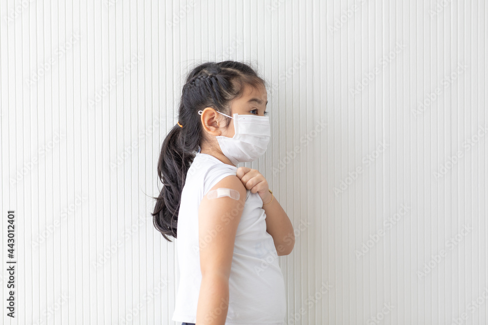 Asian cute girl wearing face mask showing vaccinated arm. Covid-19 Vaccination concept. Asian cute girl wearing face mask showing vaccinated arm. Covid-19 Vaccination concept.