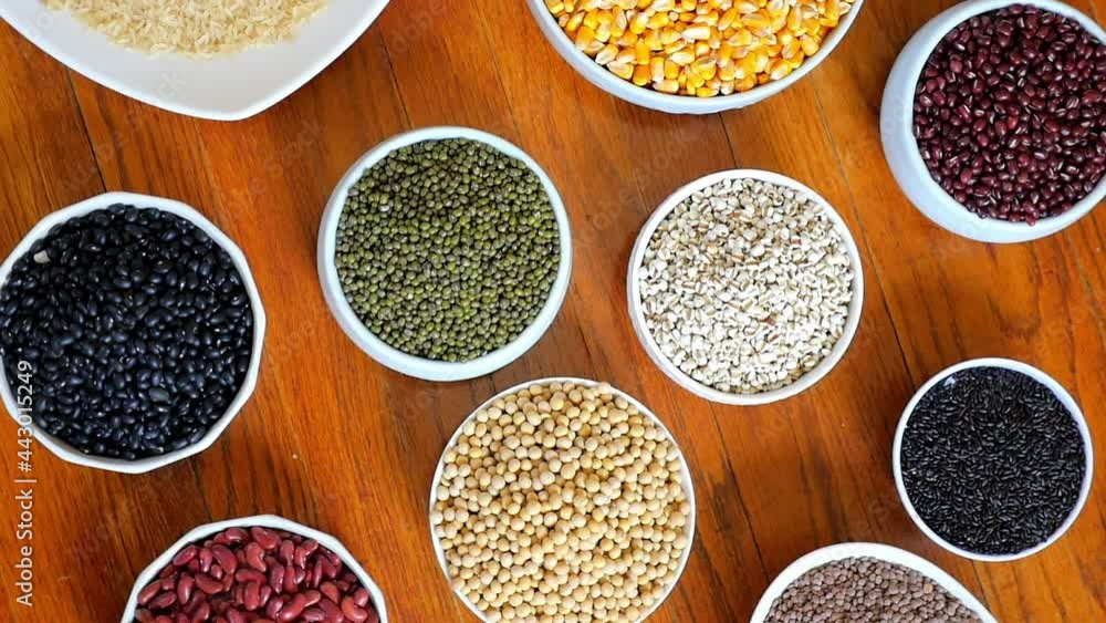 Rotating shot of healthy grains on desk: rice, corn, beans, etc., top view Rotating shot of healthy grains on desk: rice, corn, beans, etc., top view
