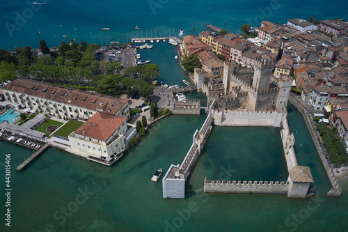 Top view of the 13th century castle. Aerial view of Sirmione Castle, Lake Garda, Italy. Italian castles Scaligero on the water. Flag of Italy on the towers of the castle on Lake Garda.