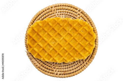 Top view of sweet homemade crispy waffles on wicker mat on white background.