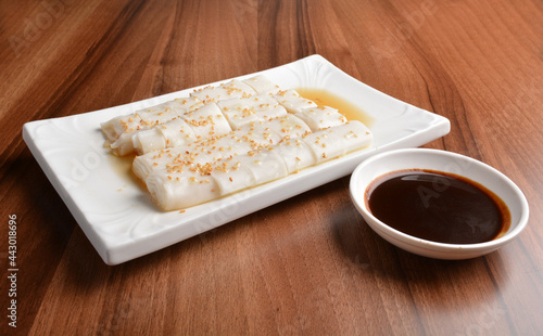 asian breakfast Chee cheong fan rice noodle with sweet sauce and sesame seed on white plate wood table chinese halal dim sum menu