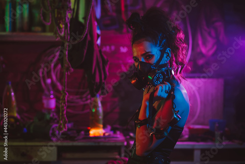 Cyberpunk cosplay. A girl in a gas mask in a post-apocalyptic style with neon lighting