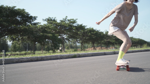 attractive fashionable asian woman skater playing surfskate on neighborhood street with fast speed like professional. female surf skating around neighbor. balancing skill enjoyment relaxation.