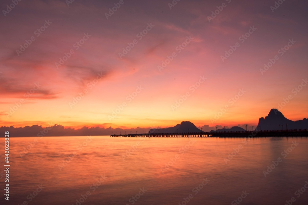 The scence of sun rising at Prachuap Khiri Khan province, Thailand, taking at dawn, early morning in the warm tone which shown the sea in motion. 