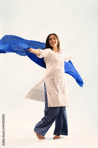 A woman in ethnic wear dancing with her chunni. photo