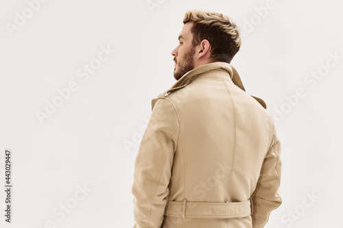 man in beige coat fashionable hairstyle back view isolated background