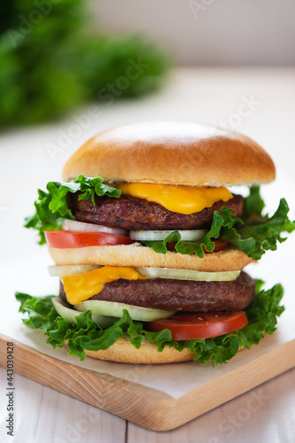 Delicious vegan cheeseburger on a wooden board.