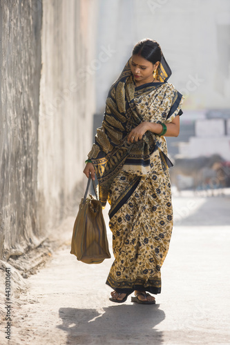 A RURAL WOMAN WALKING ALONE ON A SUNNY DAY