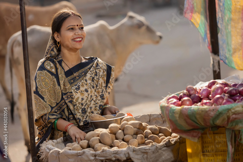 A HAPPY RURAL WOMAN BUYING VEGETABLES FROM A STREET SHOP  © IndiaPix