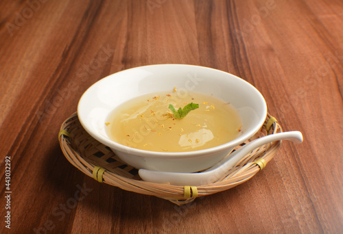 chilled sweet lemongrass jelly pudding with gui hua flower dessert in bowl on wood table asian dessert halal menu