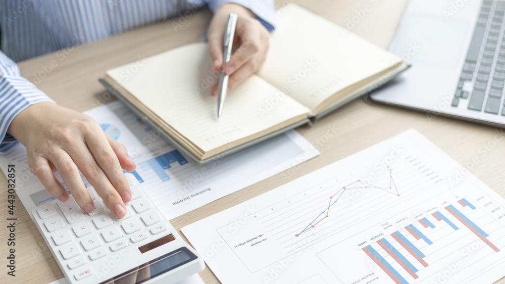 Head of accounting is recording the company's financial growth statistics using graphs as a reference for reviewing and analyzing the results, Taking notes and analyzing data graphs in office. Head of accounting is recording the company's financial growth statistics using graphs as a reference for reviewing and analyzing the results, Taking notes and analyzing data graphs in office.