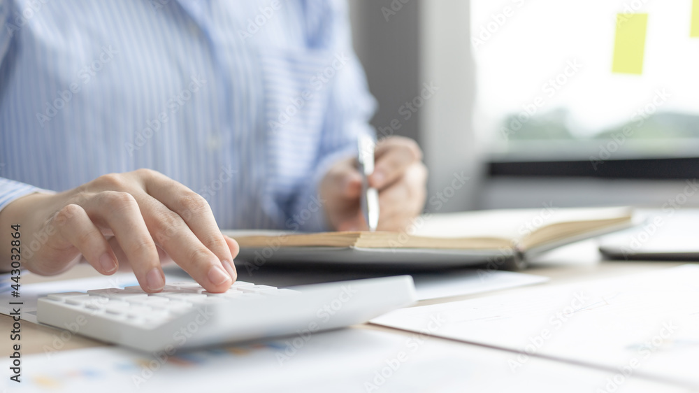 Head of accounting is recording the company's financial growth statistics using graphs as a reference for reviewing and analyzing the results, Taking notes and analyzing data graphs in office. Head of accounting is recording the company's financial growth statistics using graphs as a reference for reviewing and analyzing the results, Taking notes and analyzing data graphs in office.