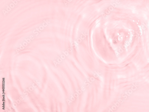 Pink water surface color background with ripples, circles and drops © tenkende