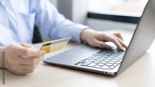 Woman s finger presses a keyboard and holds a credit card to register for payment or online transactions  Financial transactions and Internet security  Shopping online and banking online concept.