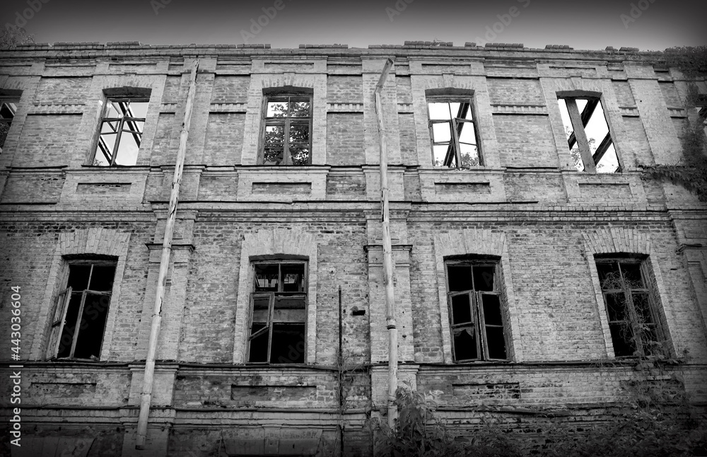 An abandoned dilapidated brick building. Black and white photo.