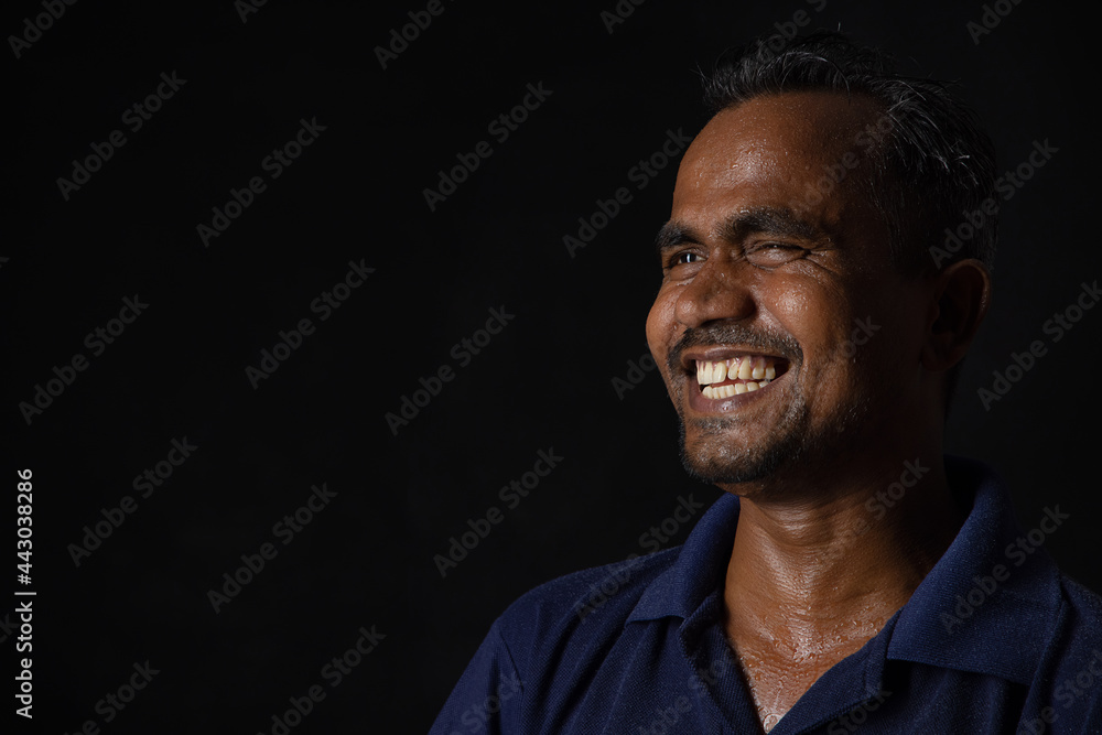 A LABOURER HAPPILY LAUGHING WHILE LOOKING AWAY A LABOURER HAPPILY LAUGHING WHILE LOOKING AWAY