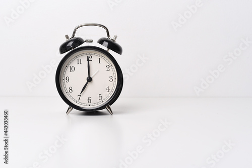 Black alarm clock on white (light) background