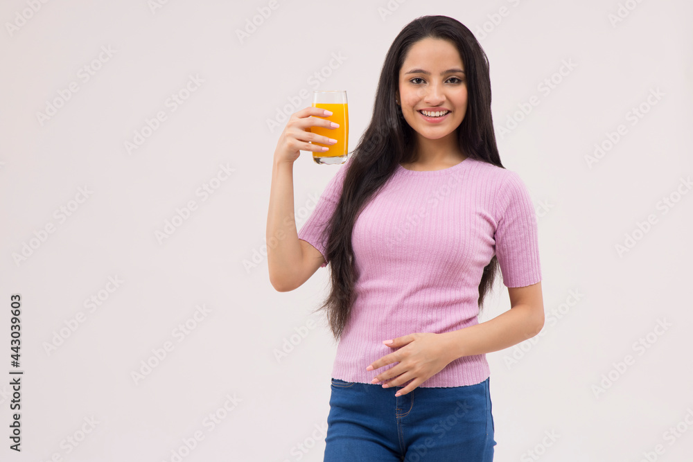 A HAPPY TEENAGER POSING WITH A GLASS OF JUICE A HAPPY TEENAGER POSING WITH A GLASS OF JUICE