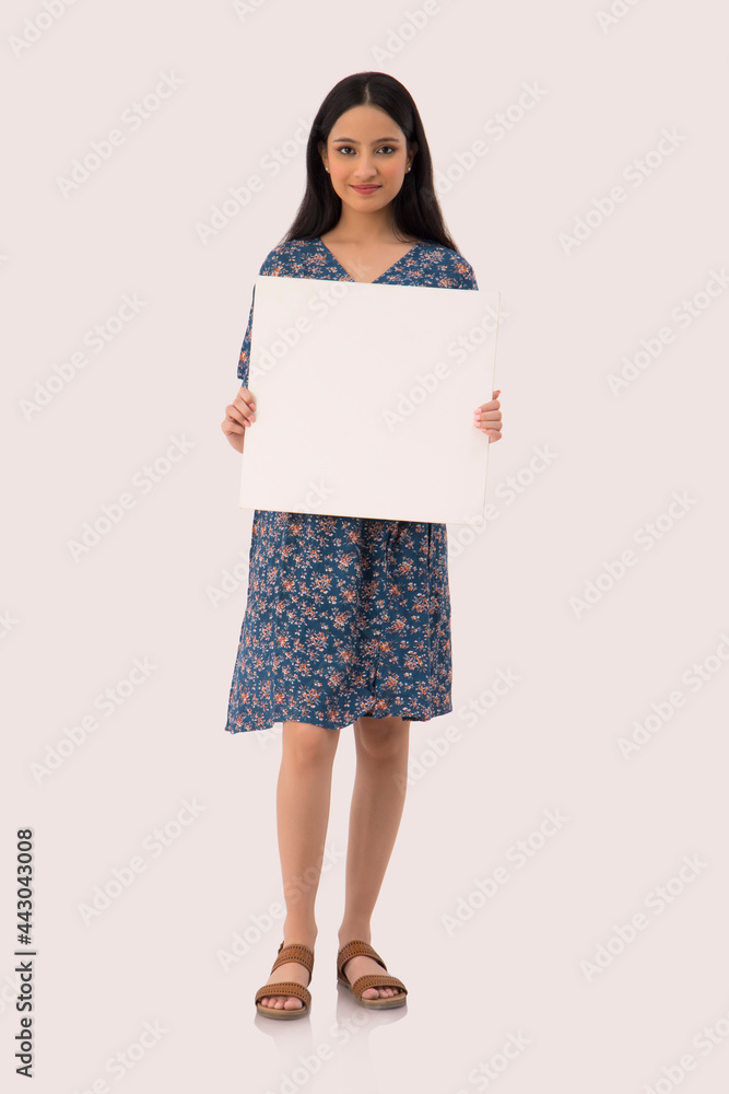 A young woman standing with a cardboard in her hand. A young woman standing with a cardboard in her hand.