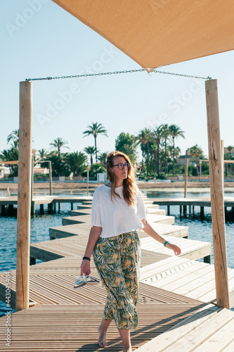 woman walking on wooden pier at the beach