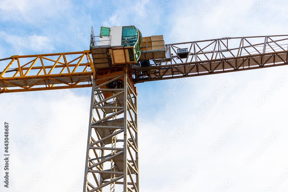 Tower crane close-up on a background of blue sky. Modern housing construction. Industrial engineering. Construction of mortgage housing.