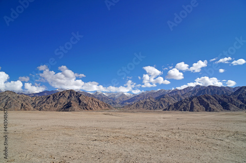 Landscape Nature scene of Desert Sand Land with himalaya snow mountain texture background  at Leh Ladakh   Jammu and Kashmir   India - blue and brown abstract outdoor travel