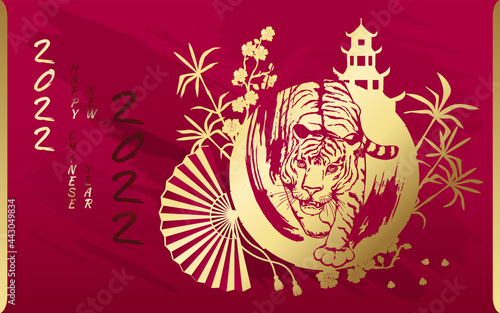 Tiger with gold on the background of a Chinese pagoda  bamboo  sakura and a fan. Happy Chinese New Year 2022. Year 2022 symbol with text.